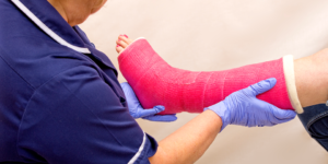 Doctor examining a pink cast on patient's leg