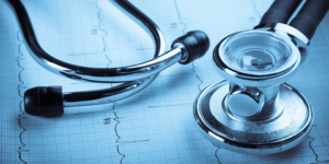 Stethoscope overlaying a printed heart rate chart